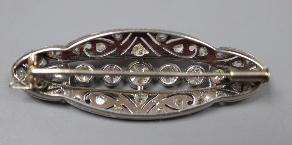 A 1920s pierced white metal and diamond set shaped oval brooch, 42mm, gross 5.8 grams.